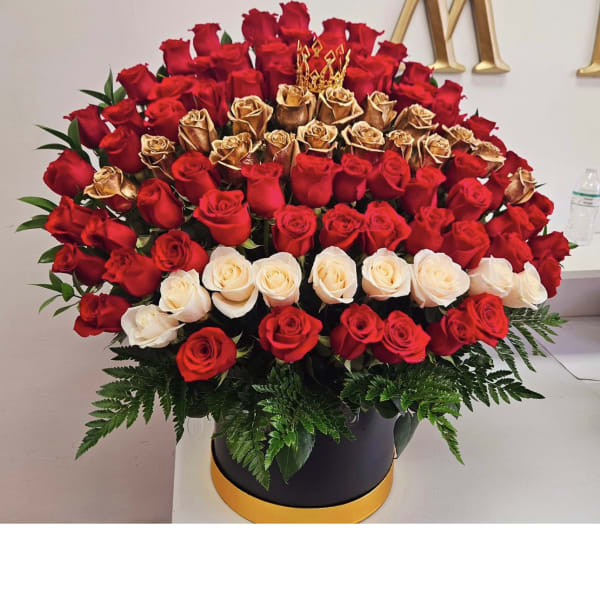 Large arrangement of red, gold, and white roses in a black hatbox