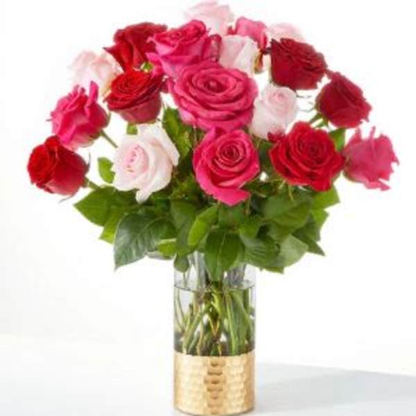 Bouquet of red, pink, and white roses in a clear glass vase