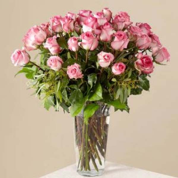 Pink roses arranged in a clear glass vase