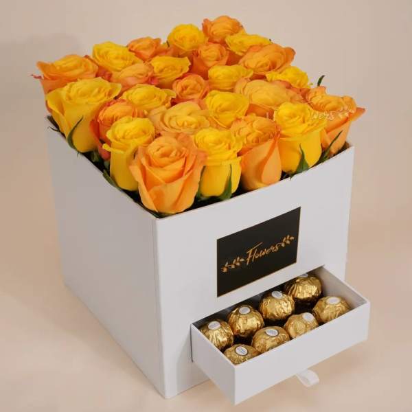 Yellow and orange roses in a white box with a drawer of chocolates
