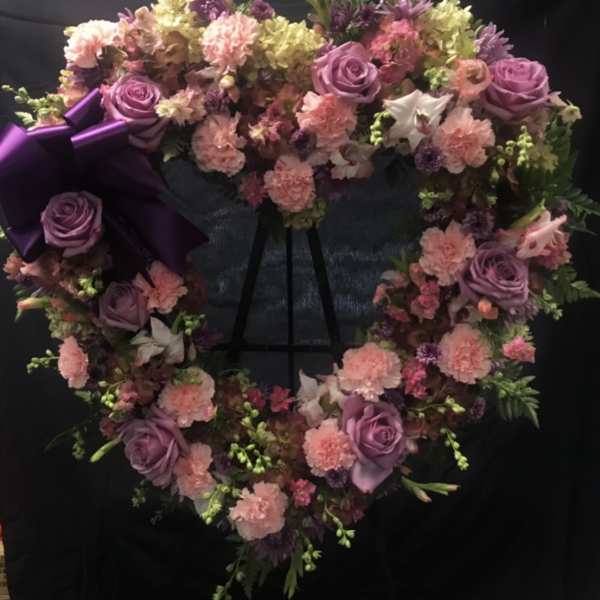 Heart-shaped floral wreath with purple roses and pink carnations