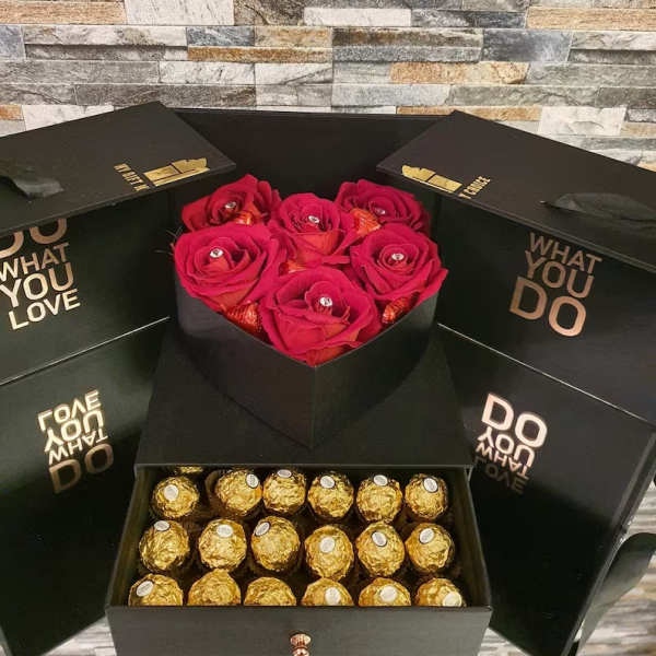 Black gift boxes with red roses and gold-wrapped chocolates