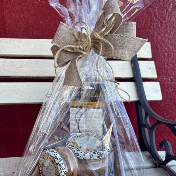 Gift basket with wrapped candles tied in a burlap bow