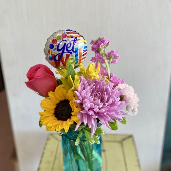 Mixed bouquet in a blue vase with a colorful balloon