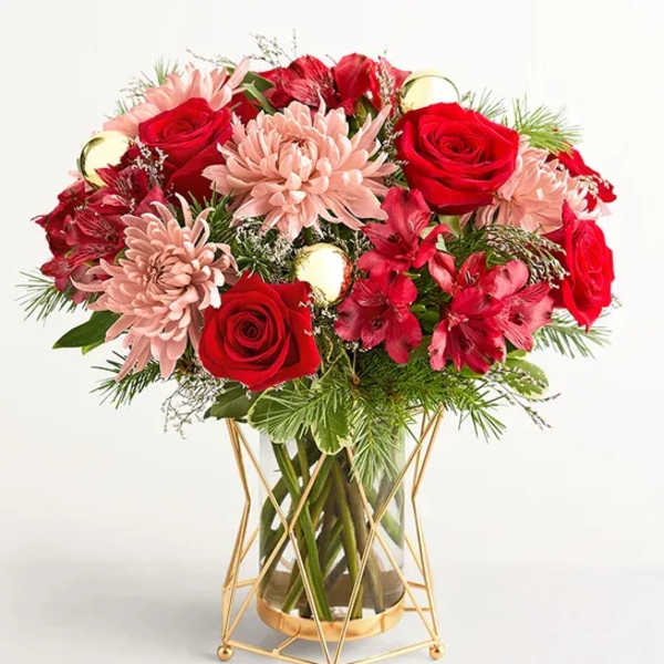 Red roses and pink chrysanthemums in a glass vase with a gold stand