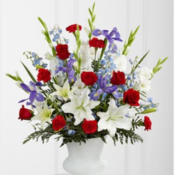 Red roses, white lilies, and purple flowers in a white vase