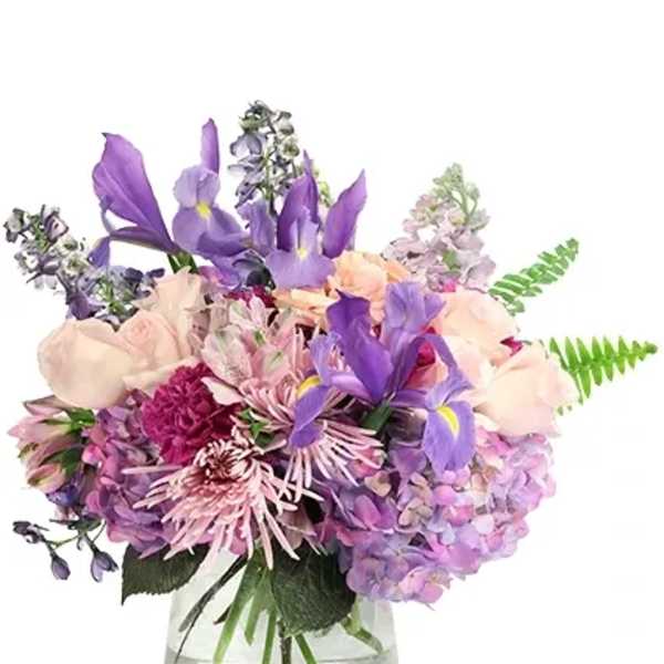 Purple and pink mixed bouquet in a clear glass vase
