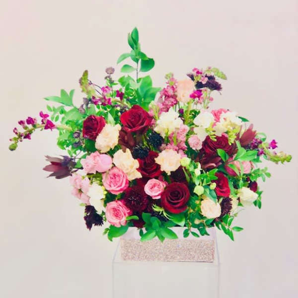 Large bouquet of red, pink, and white flowers in a box
