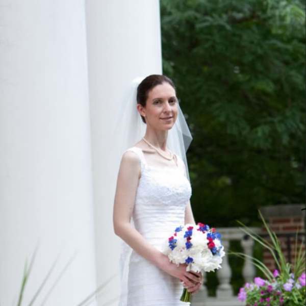 Bride in a white dress holding a white and blue bouquet