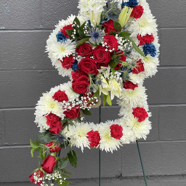 Floral standing spray in the shape of a number 4 with red, white, and blue flowers