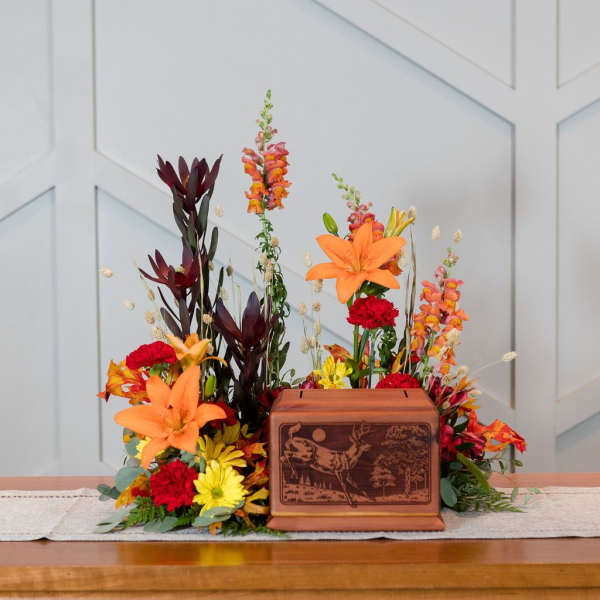 Autumn floral arrangement with lilies, snapdragons, and mums around a wooden box