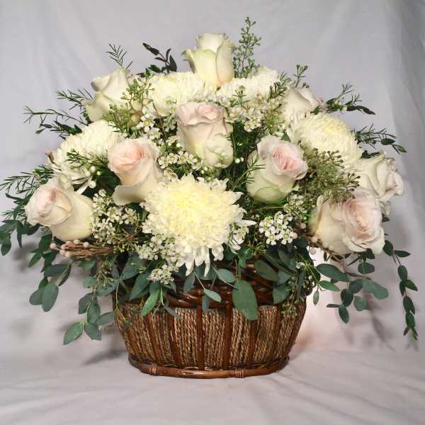 White and blush rose and mum basket arrangement with small white filler flowers