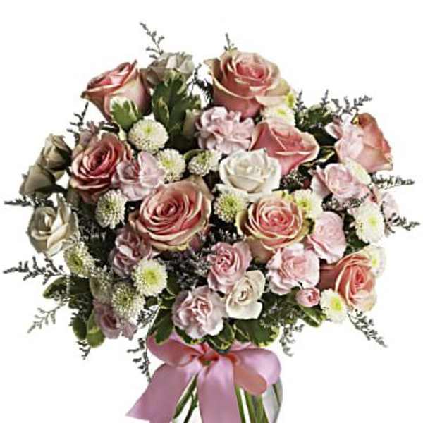 Pink and white rose bouquet in a clear glass vase with a pink ribbon
