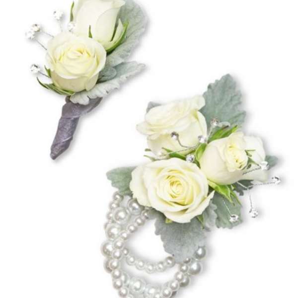 Two white rose boutonnieres with pearl accents on a white background