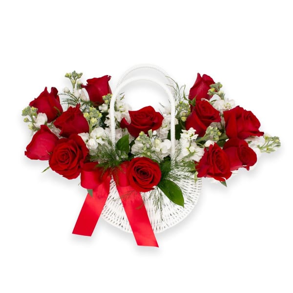 Red roses arranged in a white wicker basket with a red ribbon