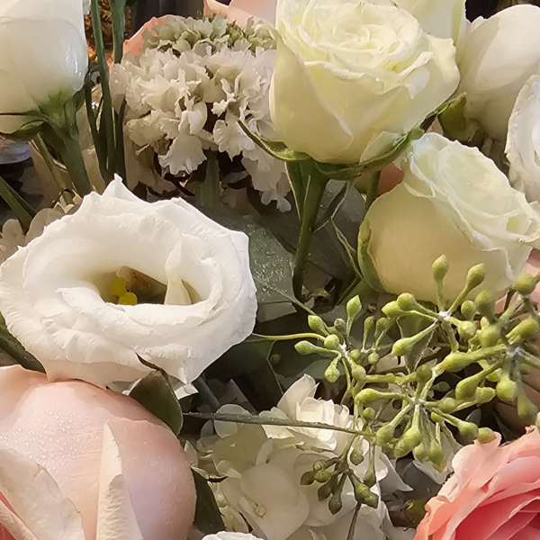 Close-up bouquet of white and pink roses with white lisianthus