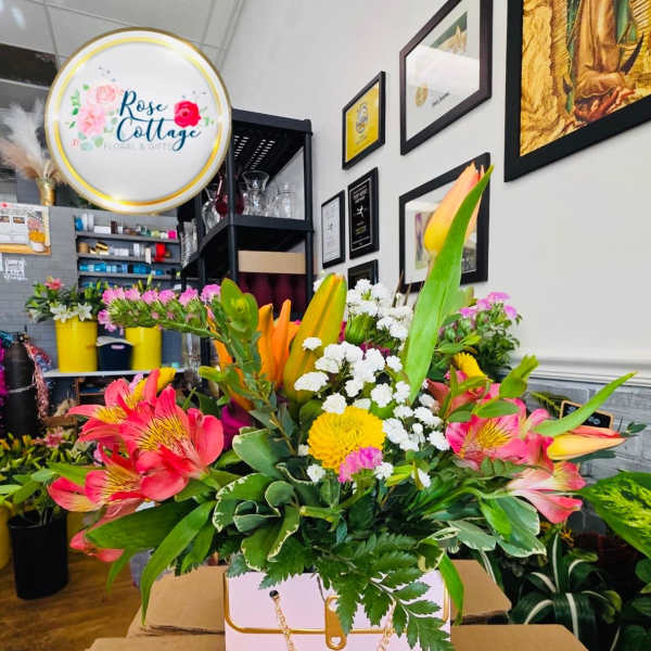 Mixed bouquet in a pink gift box with pink, yellow, and white flowers