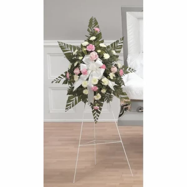 Standing floral wreath with pink and white flowers on a white easel