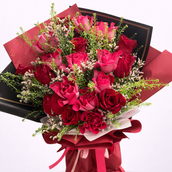 Bouquet of pink and red roses wrapped in black and red paper