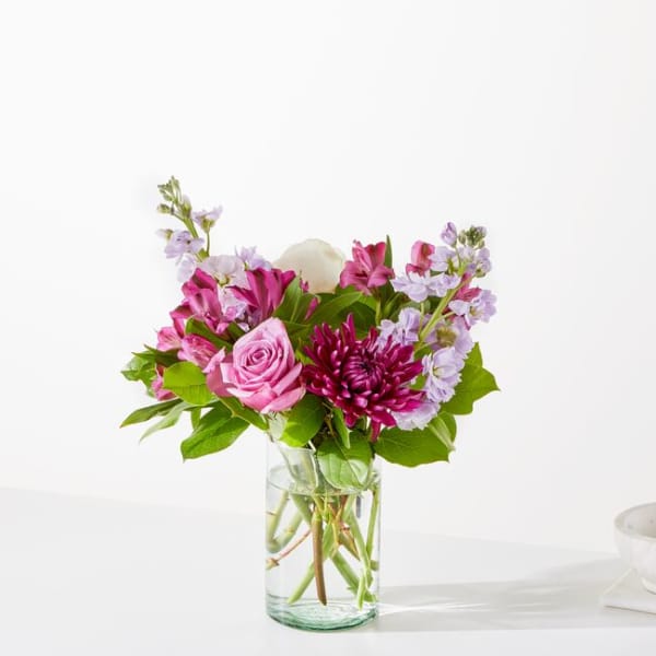 Pink and purple mixed bouquet in a clear glass vase