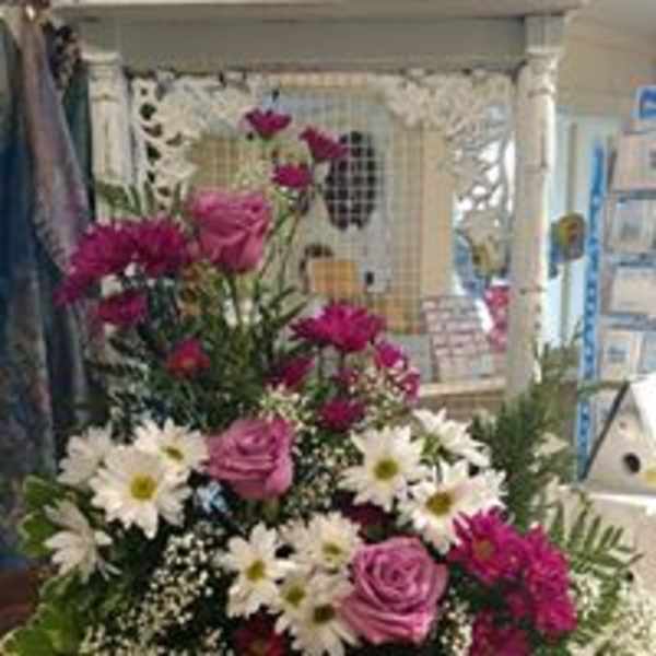 Pink roses and white daisies in a mixed floral arrangement