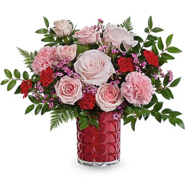 Pink roses and carnations in a red heart-patterned vase
