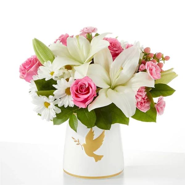 Pink roses and white lilies in a white vase with a gold dove design