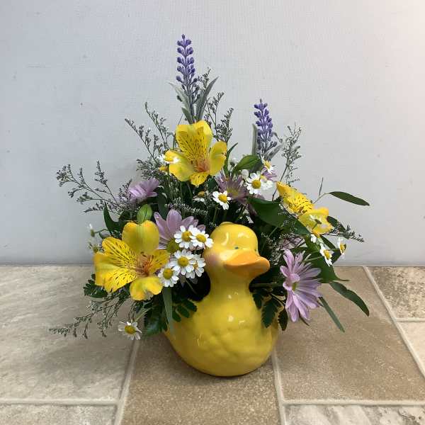 Yellow duck vase with yellow and lavender flowers