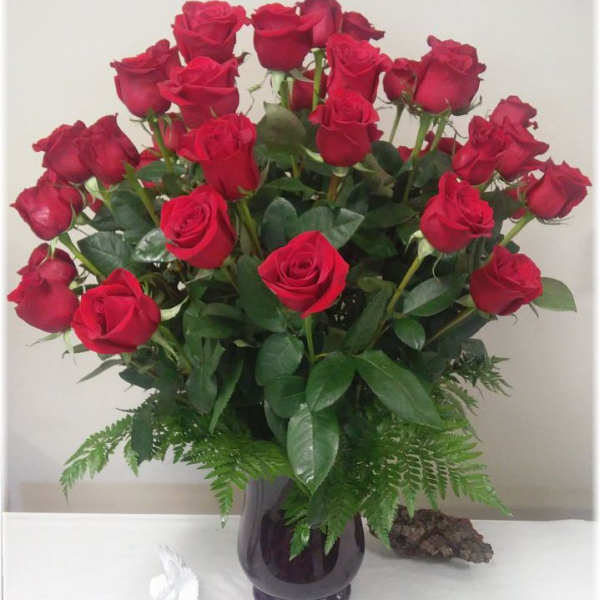 Bouquet of red roses in a dark glass vase