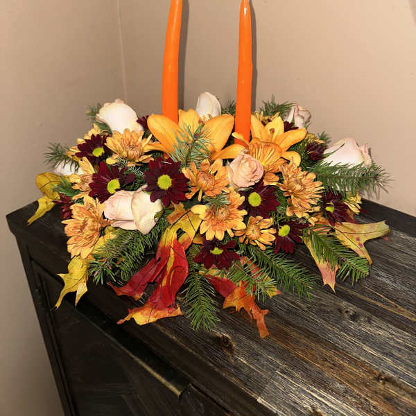 Autumn floral centerpiece with two orange taper candles