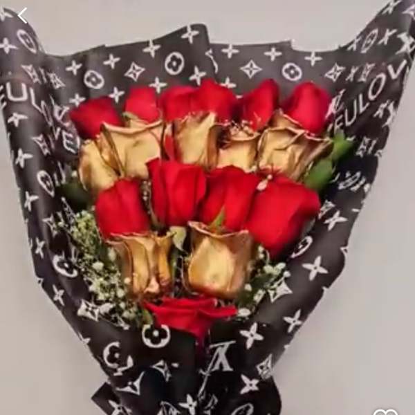 Bouquet of red roses wrapped in black patterned paper with gold accents