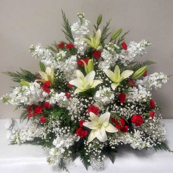 White lilies and red carnations in a large floral spray