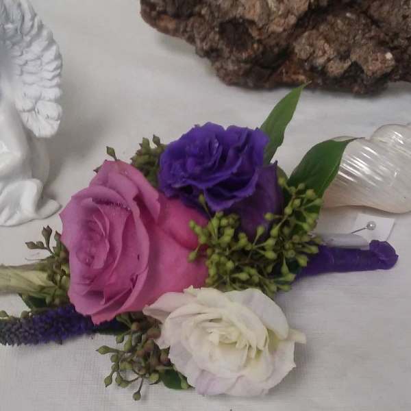 Boutonniere with pink, purple, and white roses