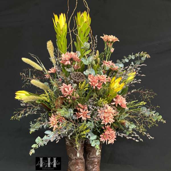 Tall floral arrangement in brown cowboy boots with pink and yellow blooms