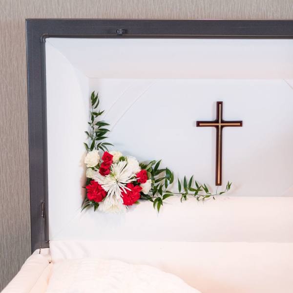 White and red floral casket spray with a cross