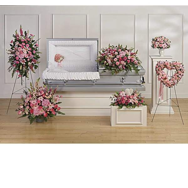Pink floral funeral casket spray with matching standing arrangements