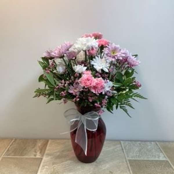 Pink and white mixed bouquet in a red glass vase with a sheer bow