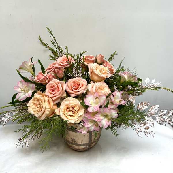 Peach roses and pink alstroemeria in a rustic vase