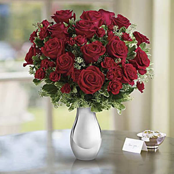 Red rose bouquet in a white vase on a table
