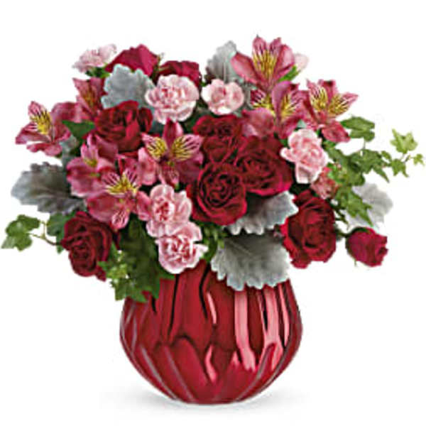 Bouquet of red roses and pink alstroemeria in a red vase