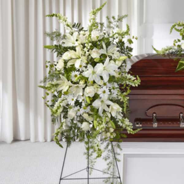 White funeral spray beside a casket