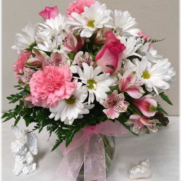 Pink and white bouquet with daisies, roses, and carnations in a glass vase