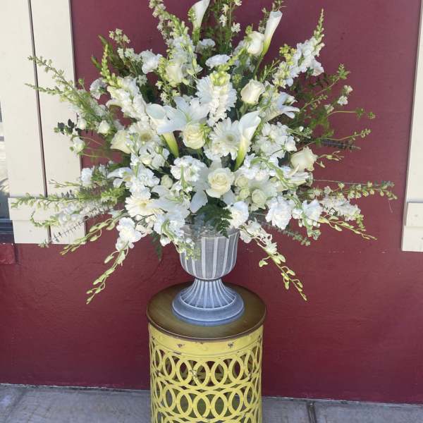 White floral arrangement in a gray urn vase