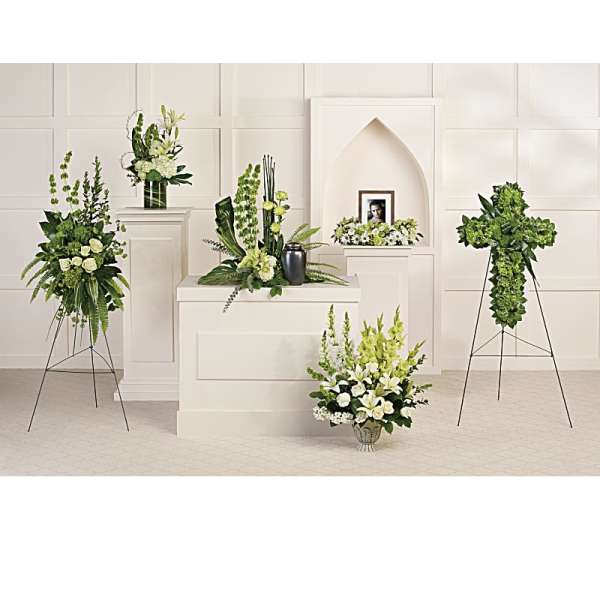 White and green funeral floral arrangements on stands and pedestals