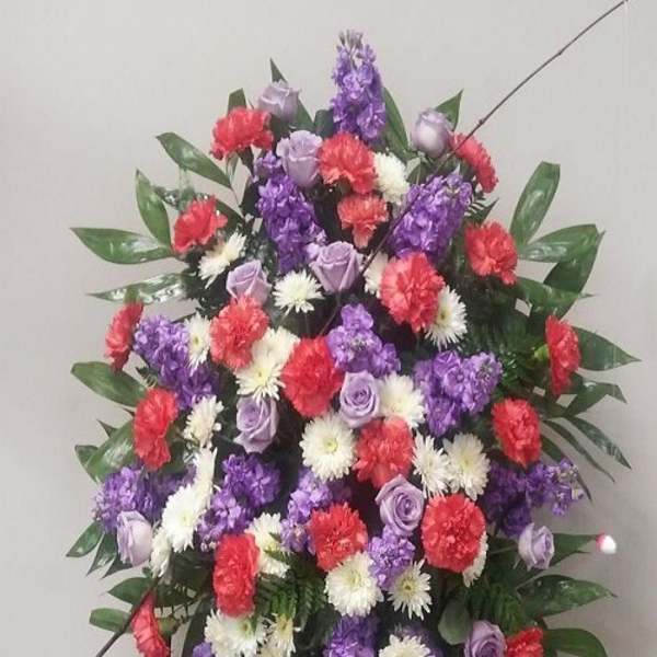 Standing floral spray with purple, red, and white flowers on an easel