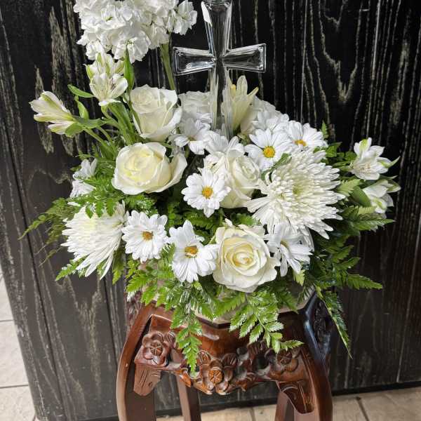 White floral arrangement with a clear cross centerpiece