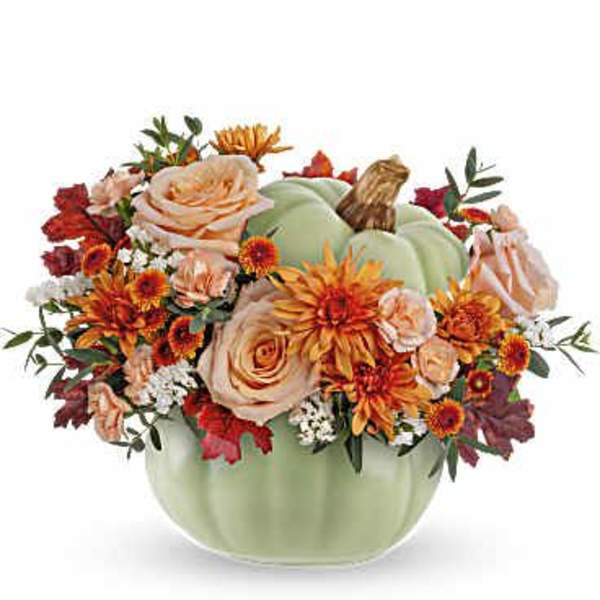 Pumpkin-shaped floral arrangement in a green container with orange and peach blooms