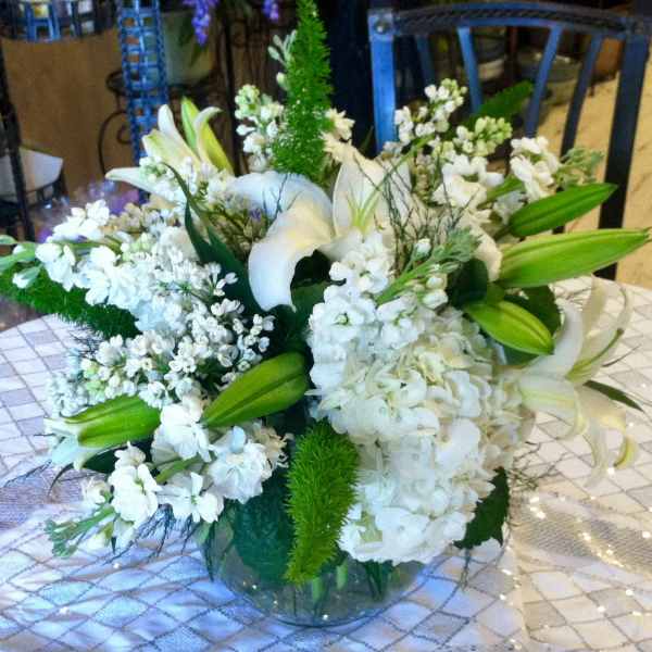 White floral arrangement with lilies and hydrangea in a glass vase