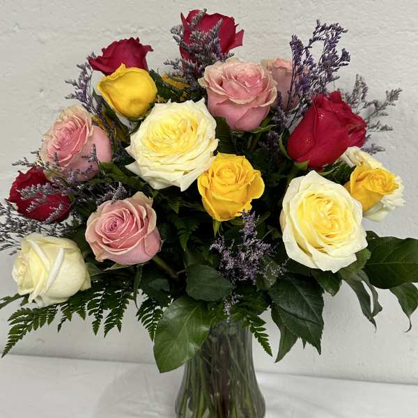 Mixed roses in pink, red, yellow, and white in a glass vase