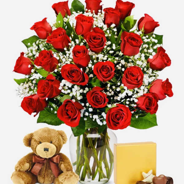Red roses in a glass vase with a teddy bear and chocolates